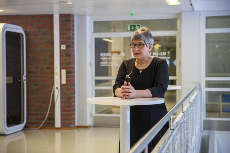 Annikki Niiranen nojaa korkeaan pöytään, joka on aulassa
