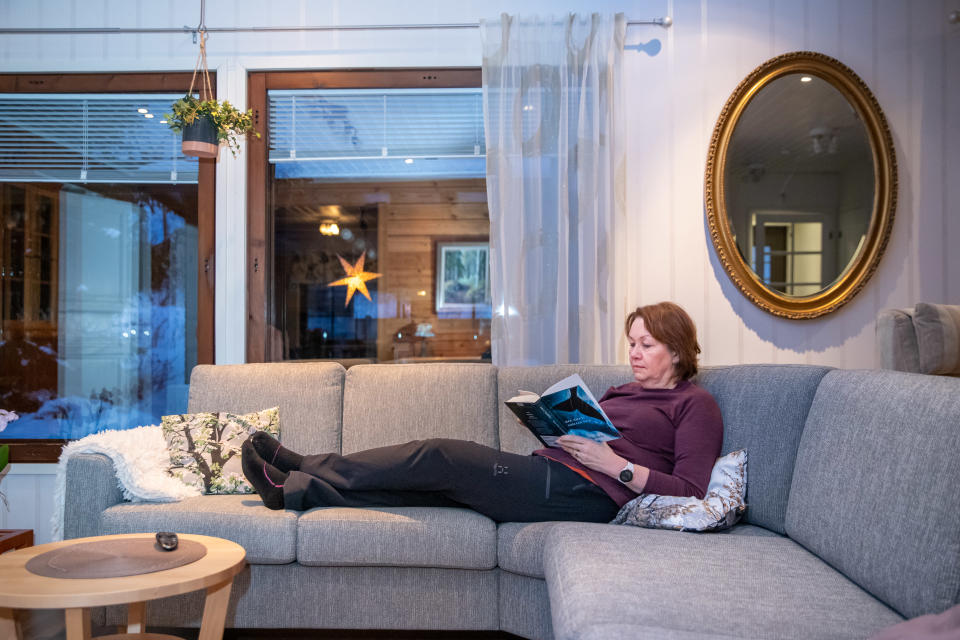 Orimattilalainen Anne Pirkkalainen lukee kotonaan kirjaa.