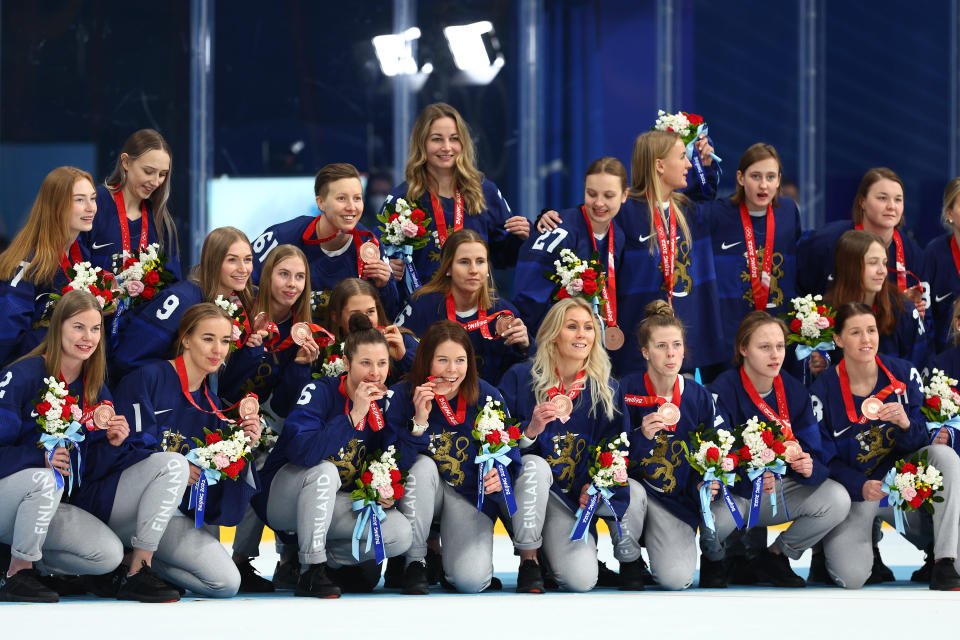 Naisleijonat poseeraavat jäällä saatuaan pronssimitalit.