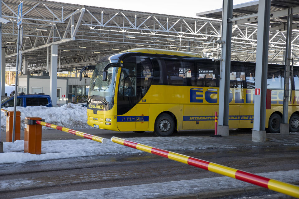 venäläinen keltainen bussi raja-aseman puomin takana talvella