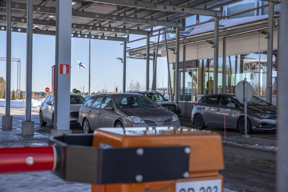 henkilöautoja kahdessa jonossa puomin takana raja-asemalla