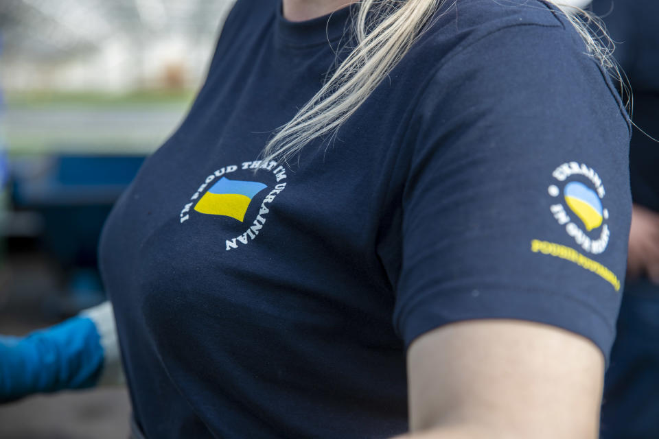 naisella on yllään t-paita, jossa on Ukrainan lippu ja lukee