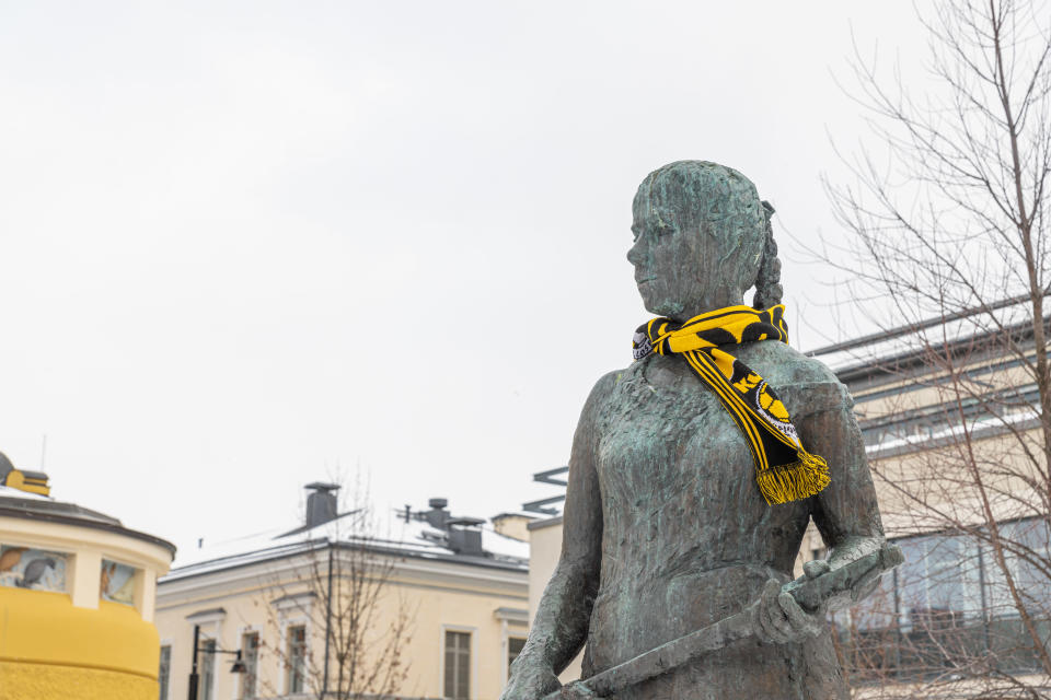 Siskontyttö-patsas Kuopion palloseuran kaulahuivi kaulassa.