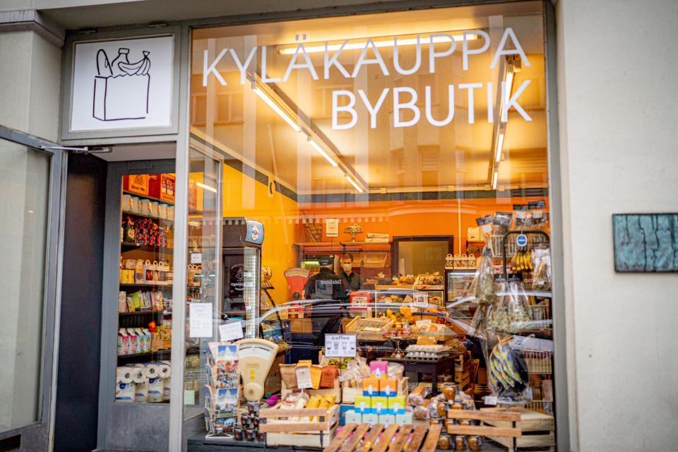 Kyläkaupan Klaus Ittonen palvelee asiakasta kyläkaupan kassalla.