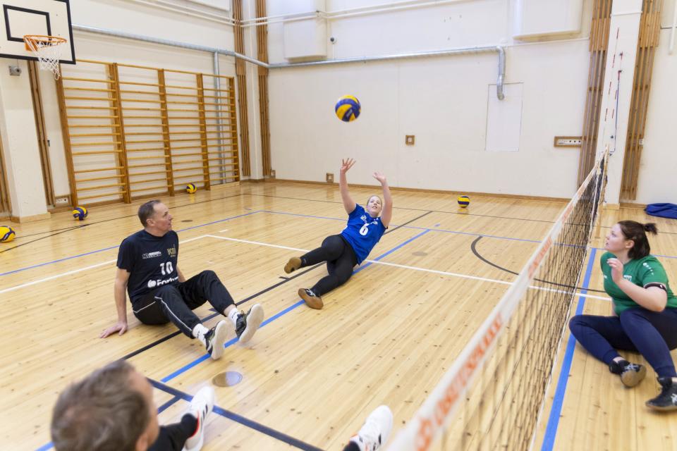Paralentopalloilijat lyövät palloa ilmaan.