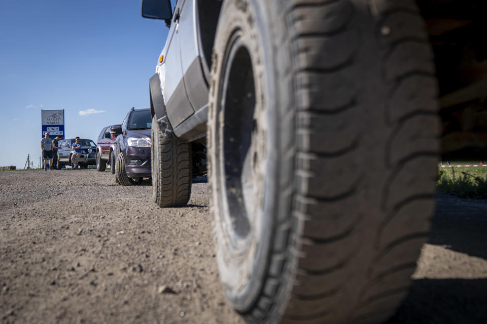 Vapaaehtoiset Ukrainaan lahjoitettavien autojensa kanssa levähdyspaikalla Liettuassa.