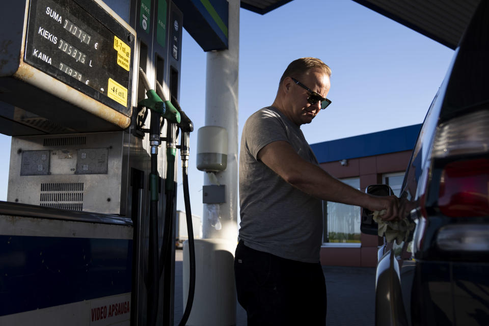 Suomalainen mies huoltoasemalla tankkaamassa autoa.