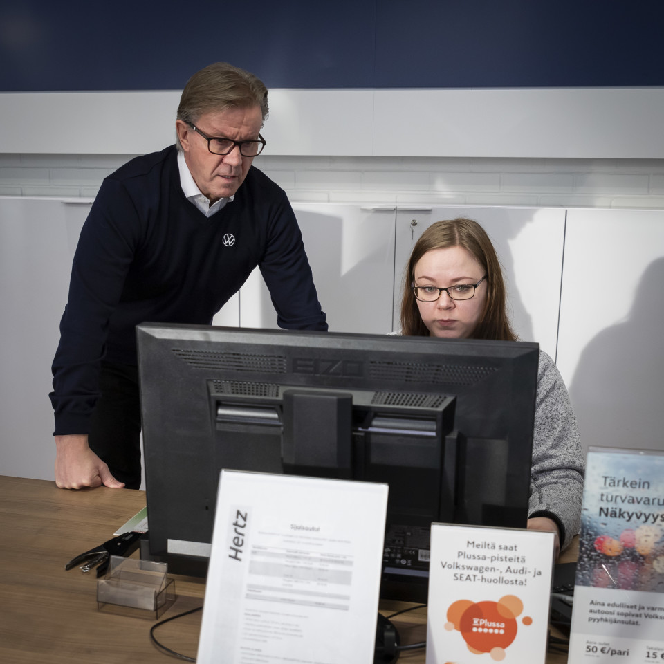 Vasemmalla Martti Kumpulainen tarkkailee vierestä, kun Terhi Takkinen tekee töitä tietokoneella.