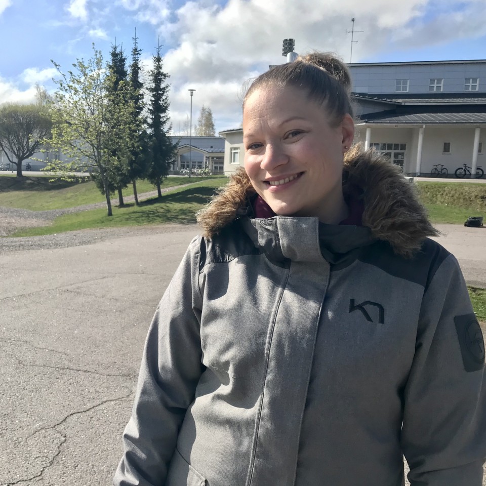Anna-Kaisa Auvinen seisomassa koulun pihalla.
