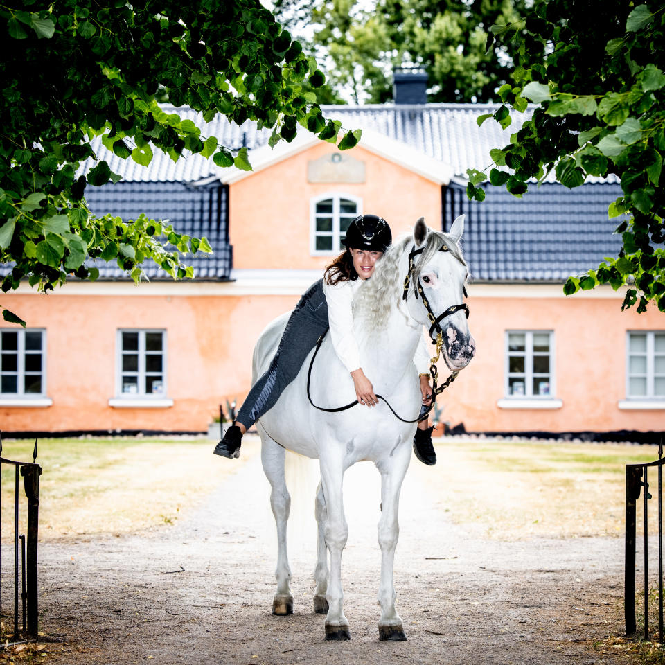 Alisa Redman andalusianhevosensa kanssa Tuomarinkylän kartanon puistossa.