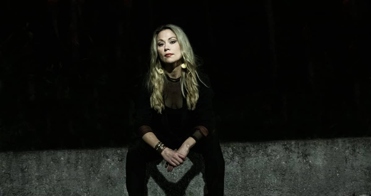 Anna Eriksson istuu mustissa vaatteissa betonilla