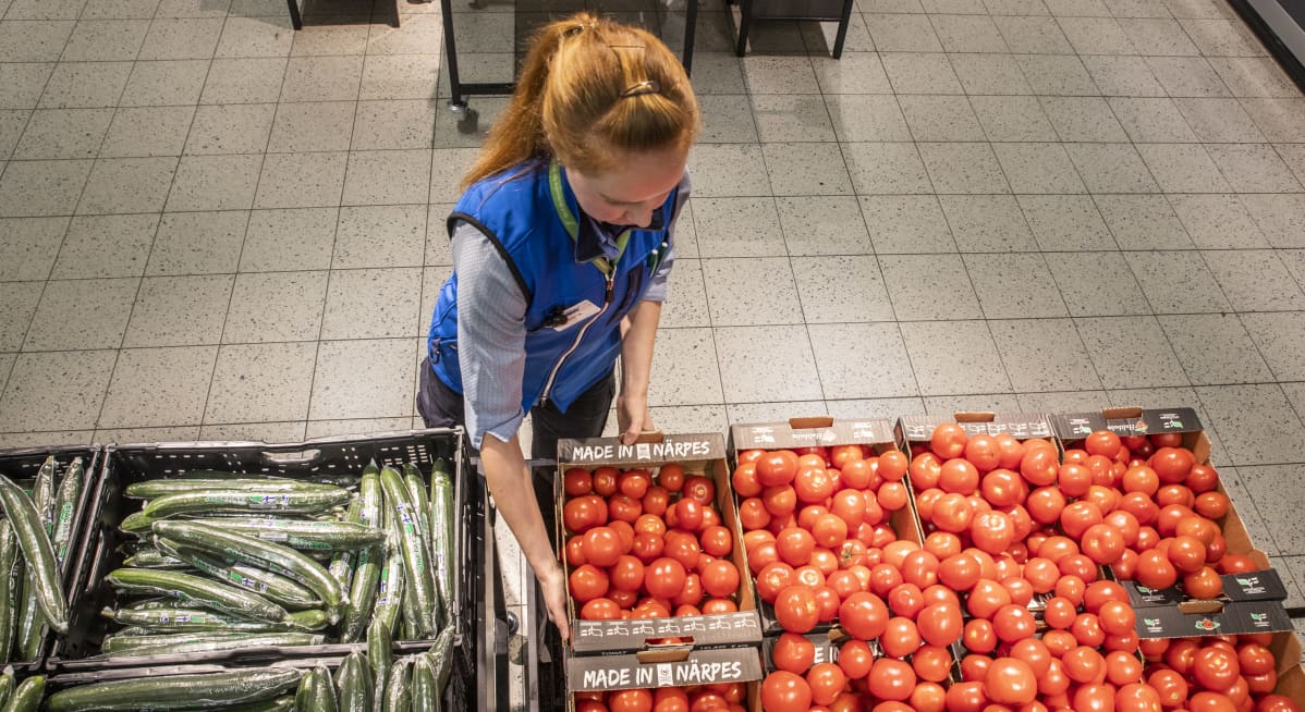 Janita Rahikainen täyttämässä vihanneshyllyjä S-Marketissa.