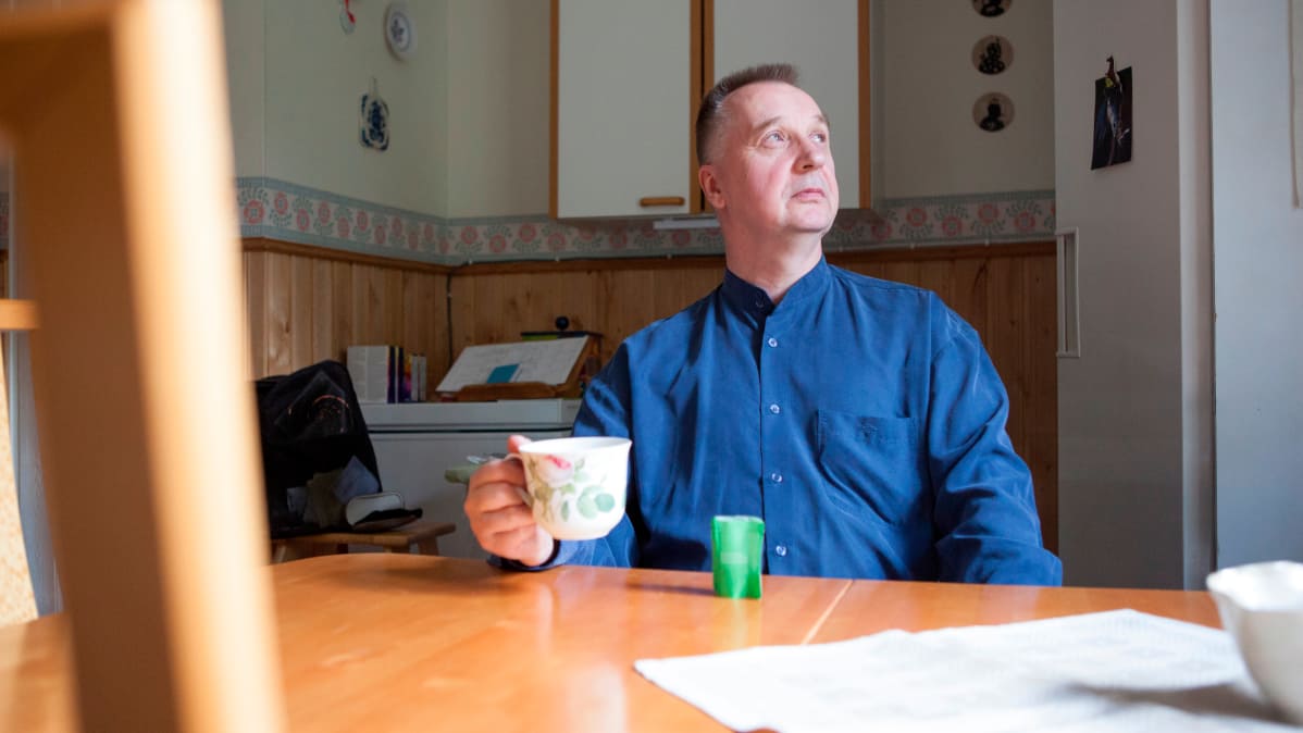 Matti Koskinen istuu keittiönpöydän ääressä juomassa teetä.