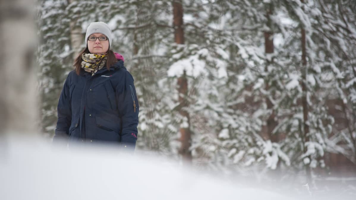 Kuopiolainen Riikka Kaisamatti seisoo metsässä.