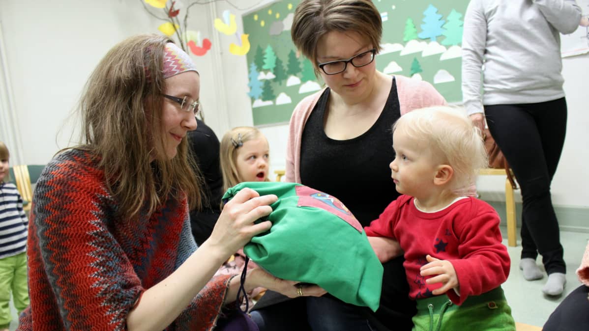 Iivari ja Henna Arresto ihmettelevät, mitä musiikkileikkikoulunopettaja Päivi Sinkkosen pussista löytyy.