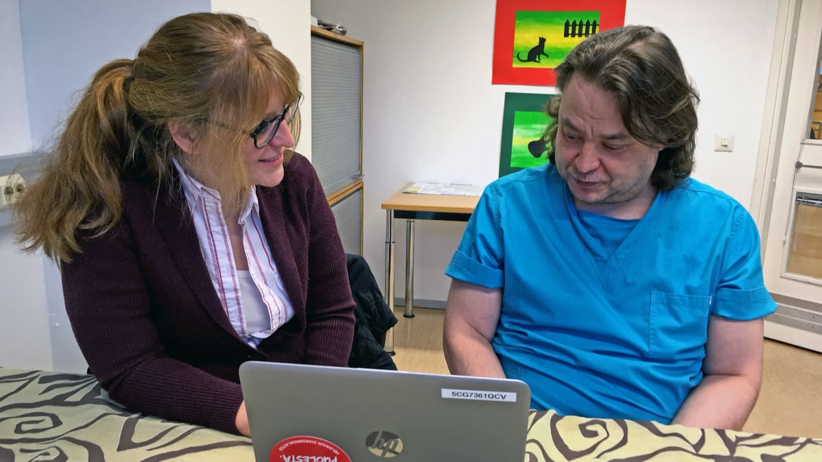 Työvalmentaja Jenni Oliveira ja Olli Honkila tietokoneen ääressä