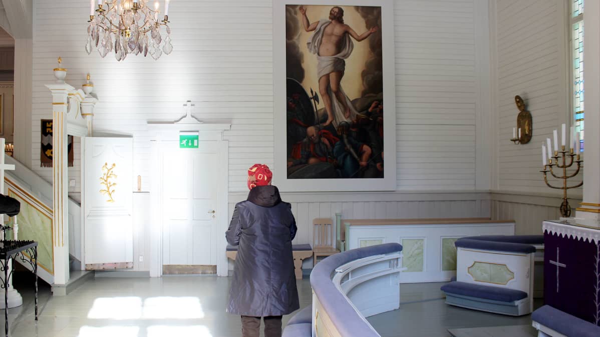 Nainen katsoo maalausta Iitin kirkossa