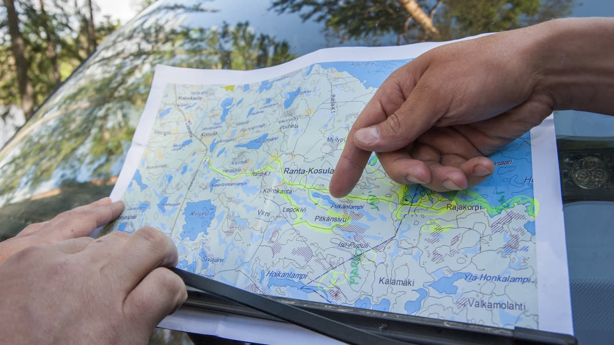 Poliisit katsovat karttaa.