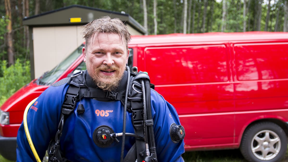 Tero Möttönen katsoo kameraa sukelluspuku päällään.