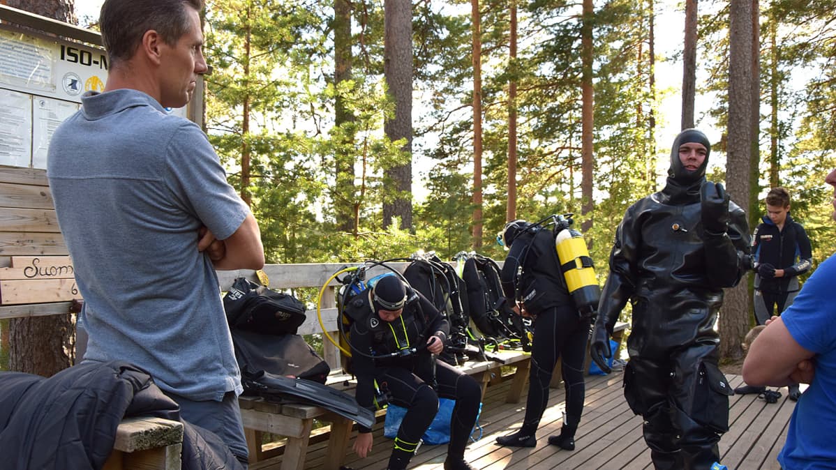 Sukeltajia rannalla valmistautumassa sukellukseen