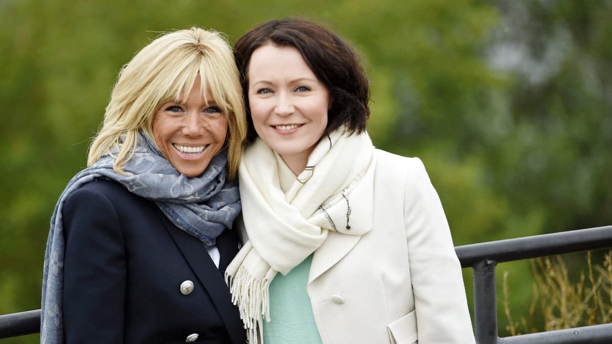 Brigitte Macron ja Jenni Haukio poseeraavat kuvaajille.