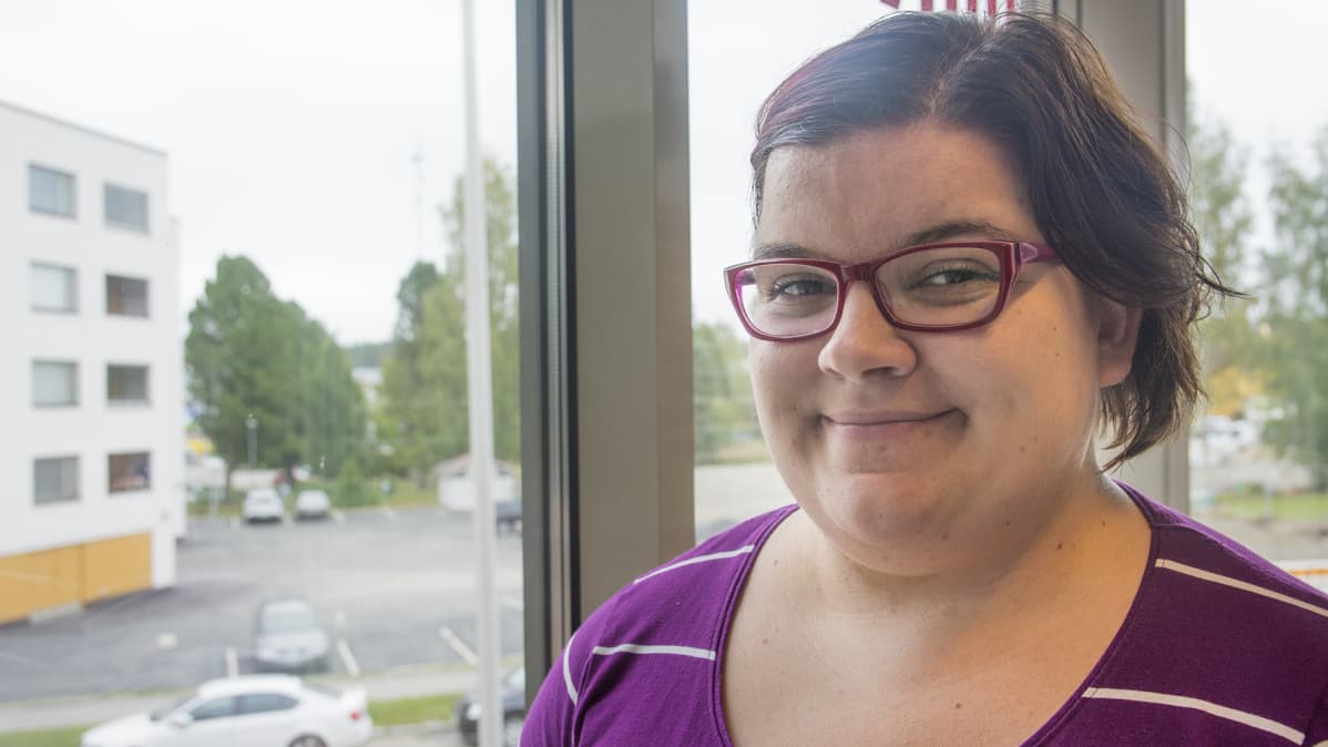 Kajaanilainen Sonja Koskelo hymyilee ikkunan edessä.