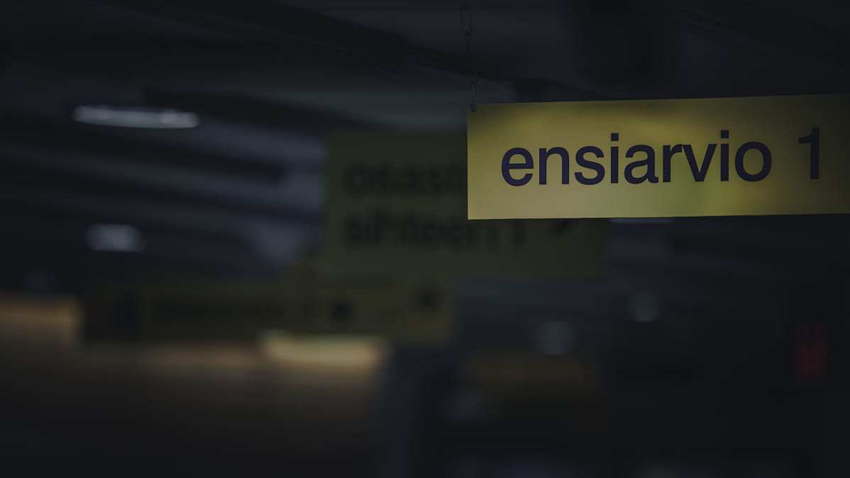 Ensiarvio-kyltti sairaalan käytävän katossa.