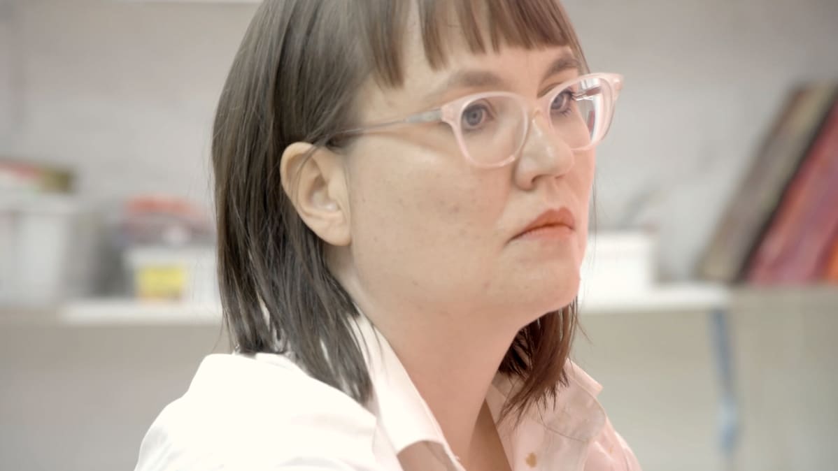 Maaria OIkarinen maalaa keskittyneenä.
