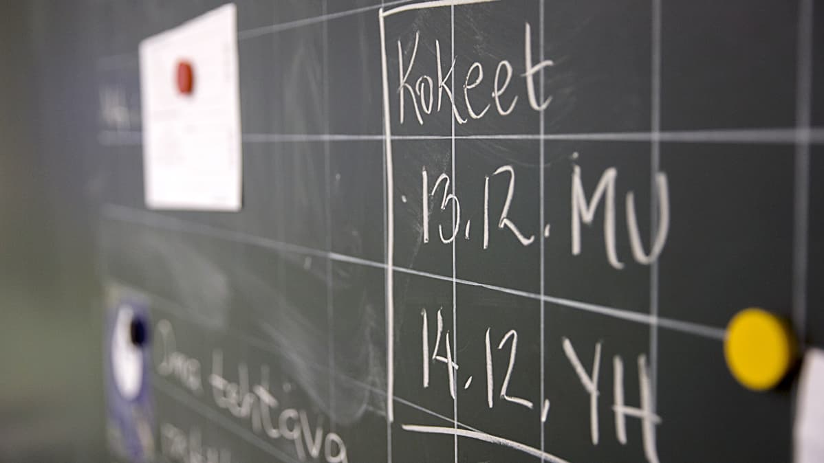 Kokeiden ajankohdasta ilmoittava teksti liitutaululla.