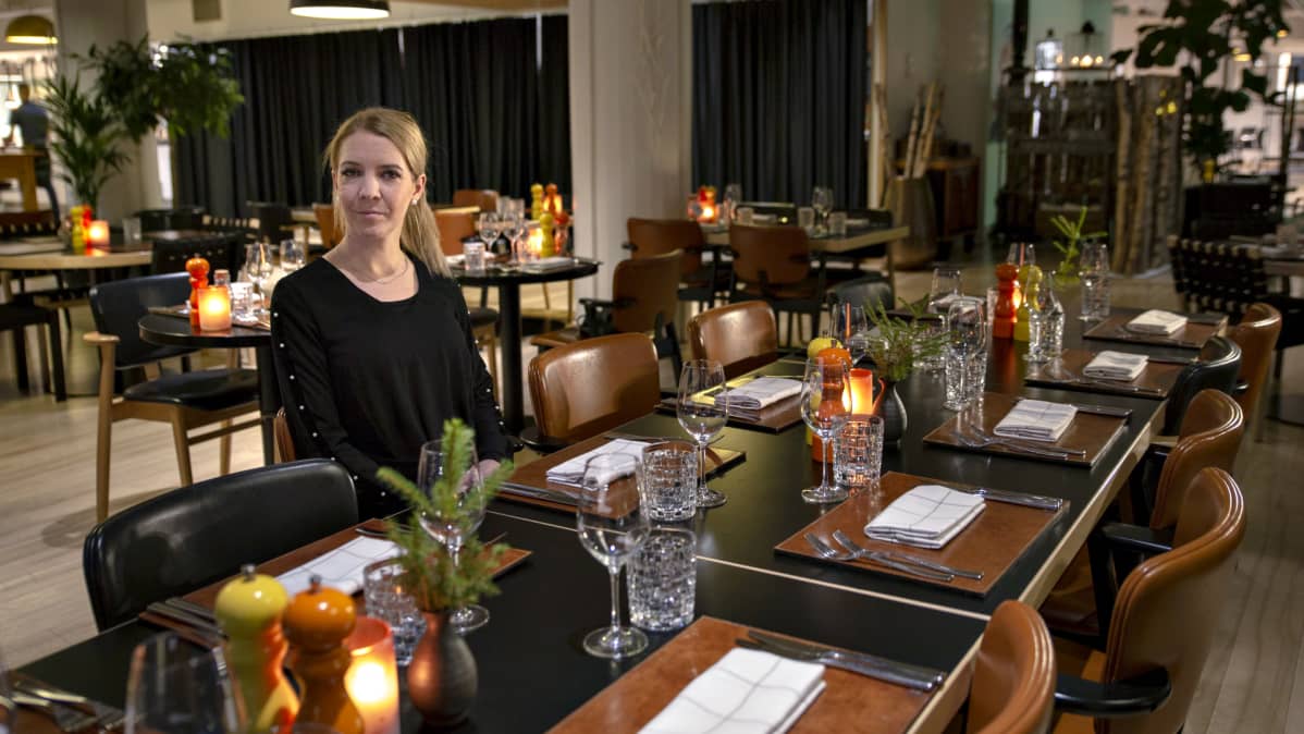 Hanna Lintumäki istuu Kitchen & Table -ravintolan pöydässä.