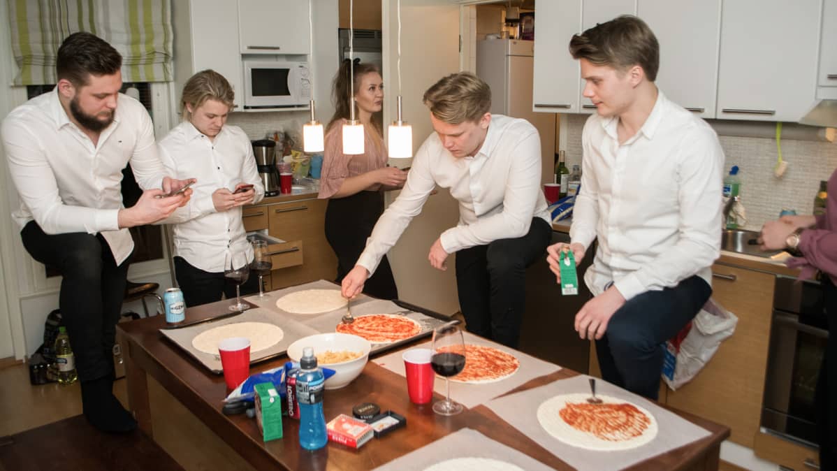 Neljä miestä tekee pizzaa kotona uuden vuoden aattona