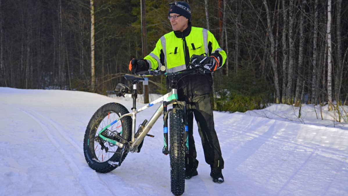 Mies näyttää, miten pieni jälki ladulle jää läskipyörän renkaasta.