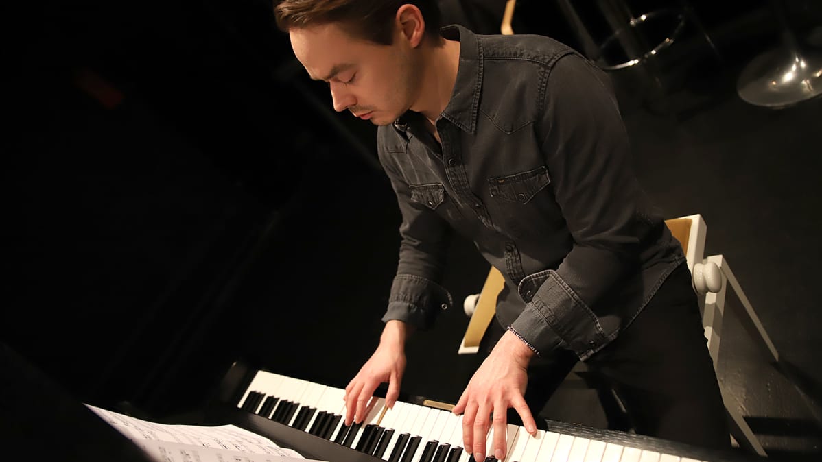 Mies soittaa pianoa