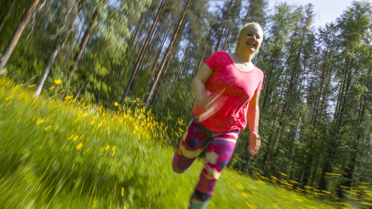 Inkeri Tiitinen juoksee niityllä.