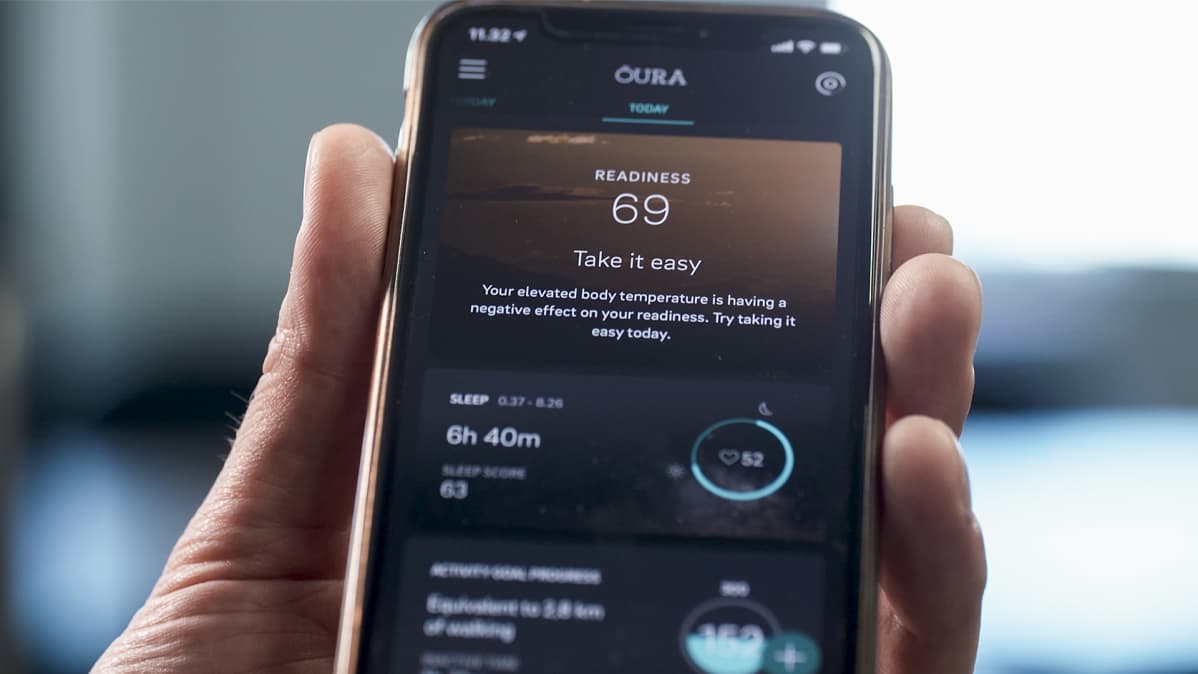 Oura Healthin sovelluksen valmius-näkymä (readiness) miehen kädessä olevan älypuhelimen näytöllä.