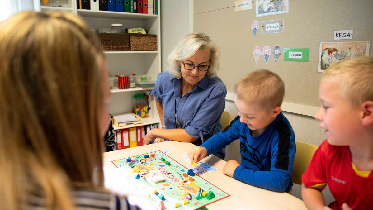 Eva Leppänen seuraa eskarilaisten lautapeli-hetkeä.