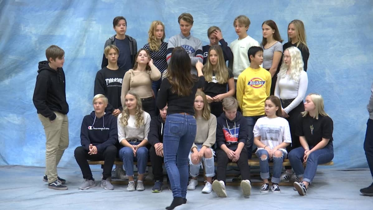 Koulukuvaaja Janina Svan (selin) järjestää Onkilahden yhtenäiskoulun 8E -luokan luokkakuvaan.