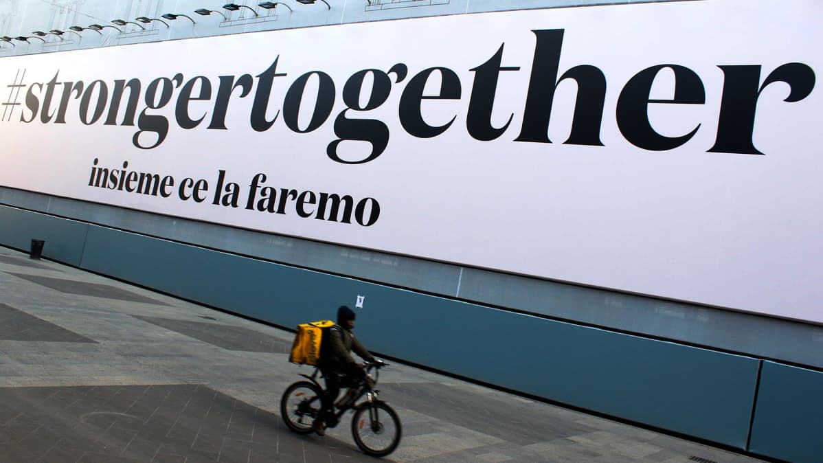 Kyltti Milanossa jossa lukee hastag strongertogether ja sen alla together we'll make it.