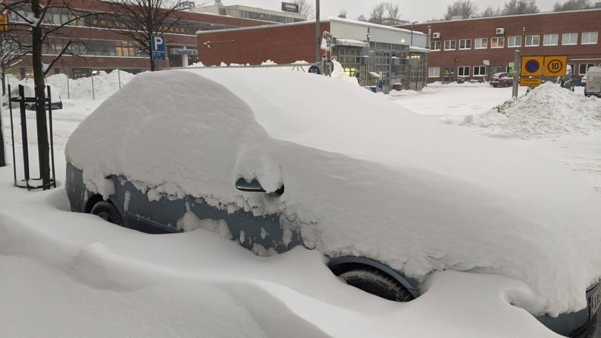 Auto hautautuneena lumeen.