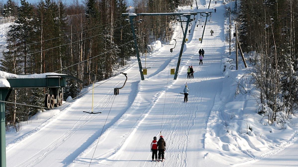 Laskettelijoita hississä Mustavaaran rinteessä.