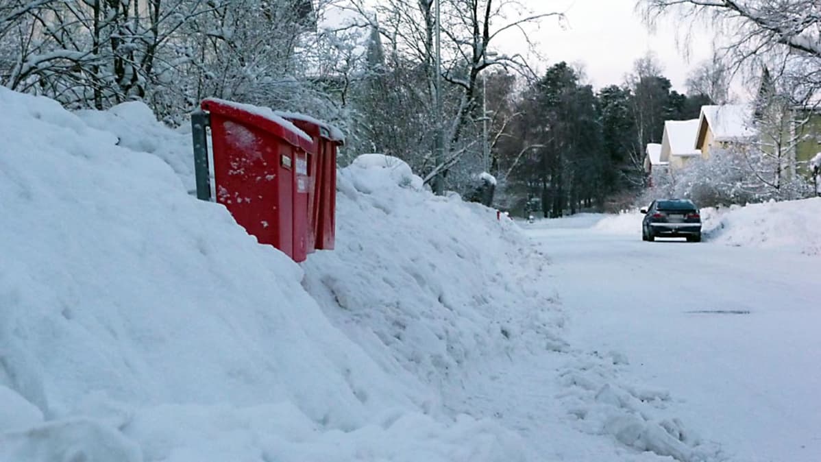 Postilaatikot törröttävät lumikasan keskellä.