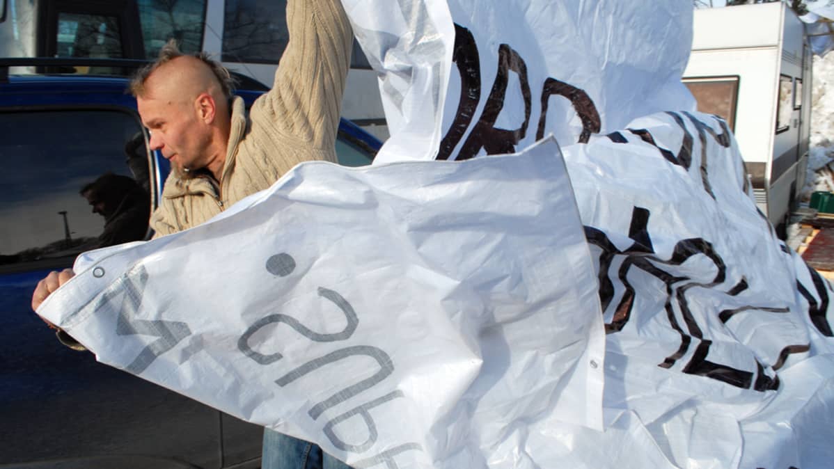 Marko Sihvonen kantaa banderollia.