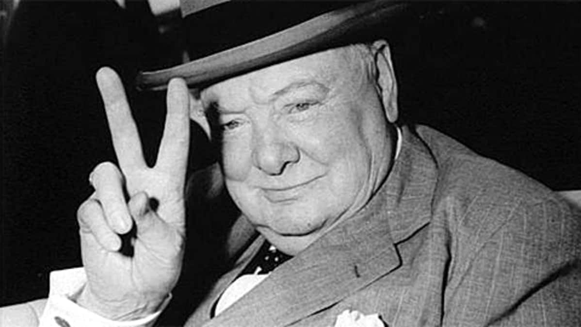Iso-Britannian pääministeri Winston Churchill näyttää voitonmerkkiä