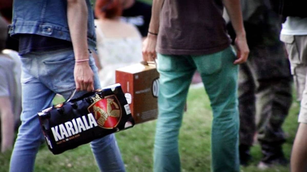 Nuoret kantavat 12-pack olutpakkauksia. 