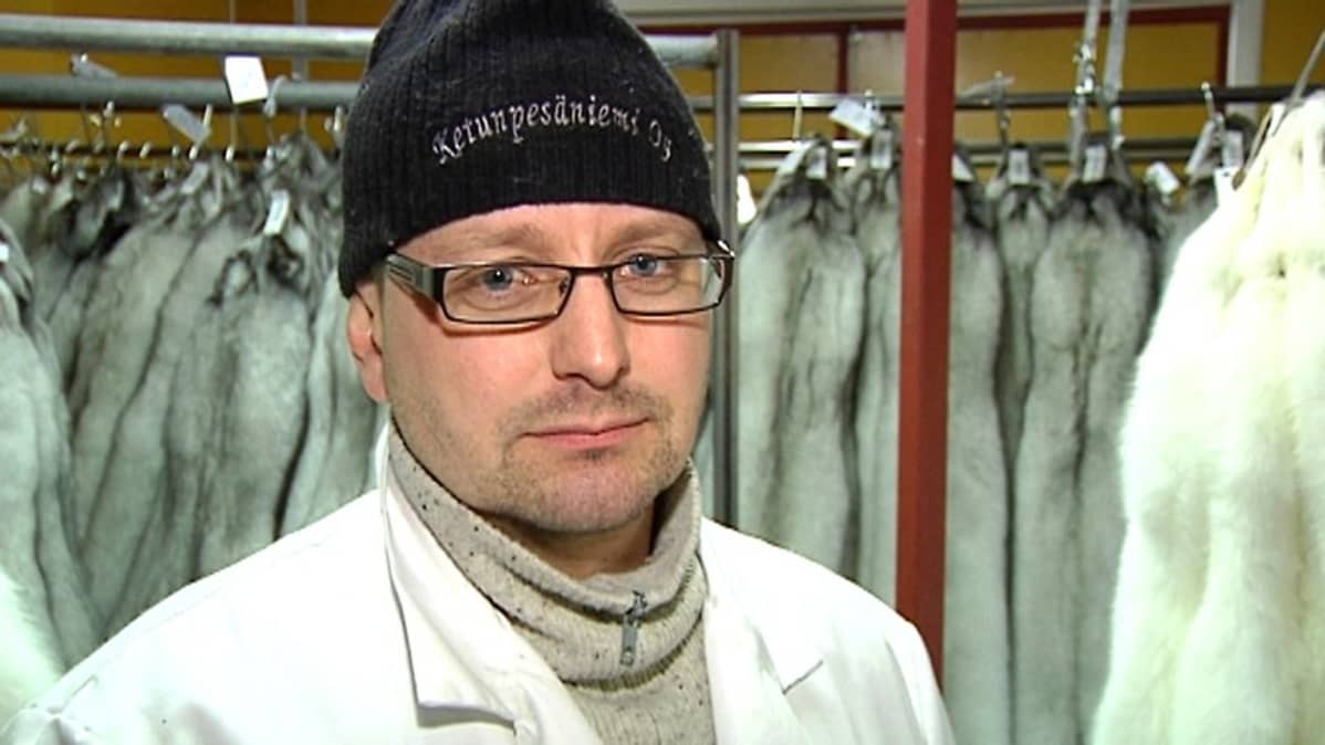 Kuvassa Mika Kokko nahkavarastossa takanaan ketunnahkoja