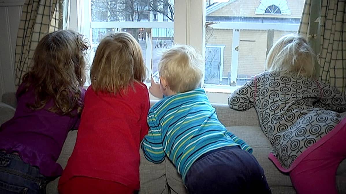 Lapsia päiväkodin ikkunassa.