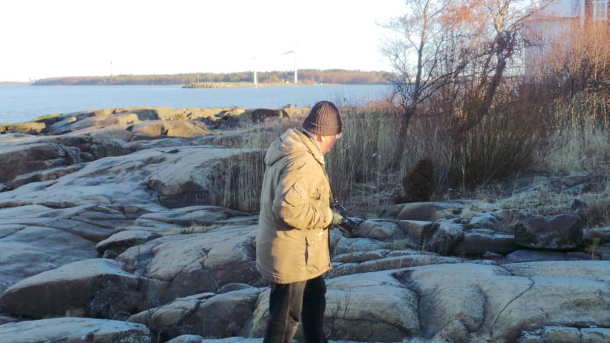 Pastori Hannu Salonoja tutkiskelee kallioihin raapustettuja muistomerkintöjä.