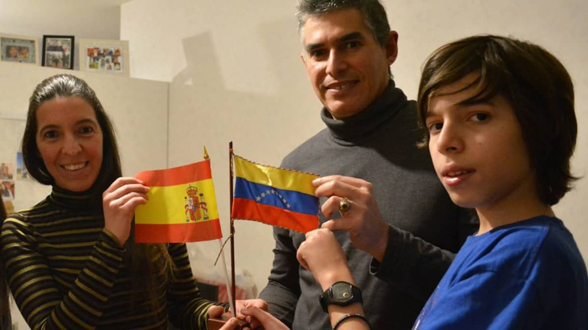 Venezuelesta Espanjaan ja sieltä Suomeen muuttanut perhe esittelee Espanjan ja Venezuelan lippuja.