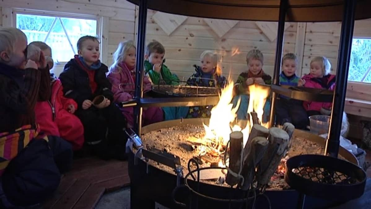 Ulkopäiväkodin lapset ruokailevat kodassa.