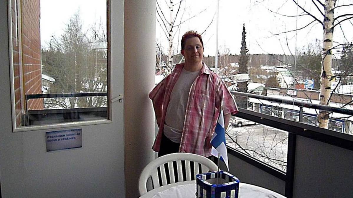 Mies seisoo parvekkeella.